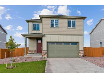 Two-story home featuring a two-car garage, green lawn, and stone details at 17969 Dandy Brush Ln, Parker, CO 80134