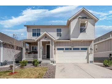 Charming two-story home with a covered porch and a two-car garage, and a well-maintained lawn at 27857 E 8Th Ave, Aurora, CO 80018
