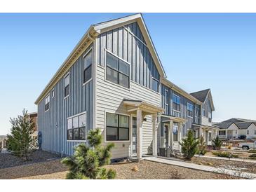 Attractive townhome exterior with blue and beige siding, complemented by neatly landscaped front yard at 7885 Yampa River Ave, Littleton, CO 80125