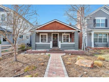 Charming gray single-story home with a red brick walkway and a welcoming front porch at 2033 S Ogden St, Denver, CO 80210
