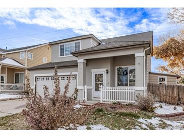 Charming two-story home featuring a gray stucco exterior, covered porch, and attached two-car garage at 3869 S Himalaya Way, Aurora, CO 80013