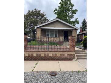 Charming brick bungalow with a well-maintained front yard and decorative wrought iron fence at 3036 W Clyde Pl, Denver, CO 80211