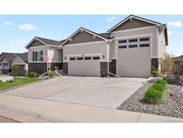 Charming home with a large driveway, three-car garage, and manicured front yard with tasteful stone accents at 6196 Leilani Dr, Castle Rock, CO 80108