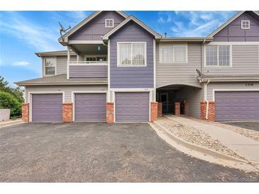 Multi-Gathering exterior with garage doors and brick accents in a residential neighborhood at 1308 S Danube Way # 102, Aurora, CO 80017