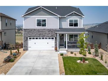 Charming two-story home featuring a stone facade, attached garage, and manicured front yard at 15946 Little Bluestem Rd, Monument, CO 80132