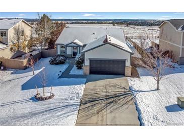 Beautiful single Gathering home featuring a driveway with a large garage and a well manicured lawn at 1180 Crenshaw St, Castle Rock, CO 80104