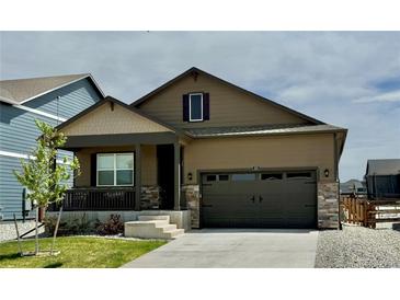 Charming one-story home featuring a covered porch, attached garage and nicely manicured front lawn at 222 Fox St, Bennett, CO 80102