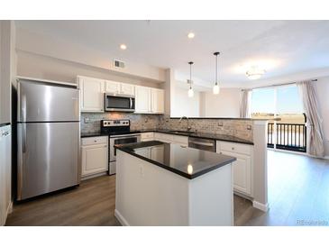 Bright kitchen features stainless steel appliances, granite countertops, island, and an open floorplan at 1785 Morrison Ct, Superior, CO 80027