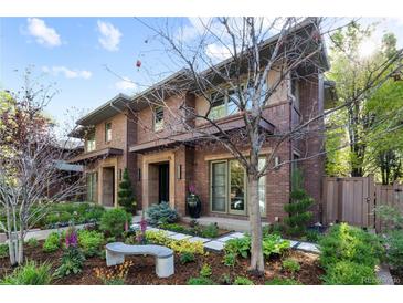 Two story brick home features manicured landscaping and a charming bench out front at 318 Adams St, Denver, CO 80206