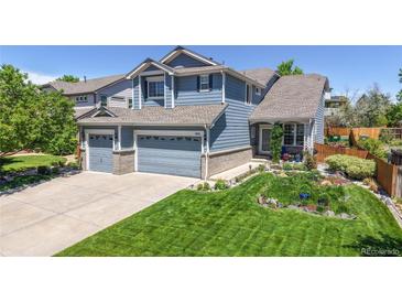 Charming blue two-story home with a manicured lawn and a three-car garage offering great curb appeal at 4826 S Ireland St, Aurora, CO 80015