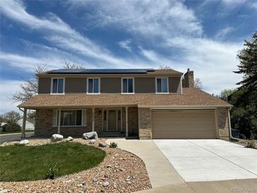 Charming two-story home featuring a manicured lawn, complemented by solar panels and an attached two-car garage at 3298 W 11Th Avenue Pl, Broomfield, CO 80020