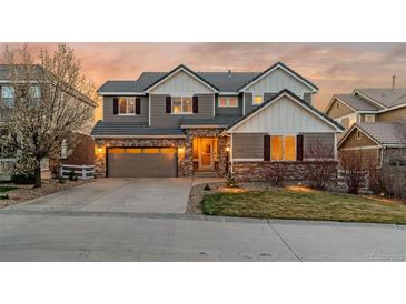 Charming two-story home with a brick and siding facade, garage, and well-manicured lawn at sunset at 1609 S Catawba Cir, Aurora, CO 80018