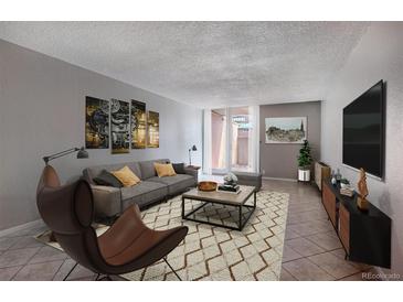 Inviting living room with comfortable seating, stylish decor, and a sliding glass door to a private patio at 2500 S York St # 115, Denver, CO 80210