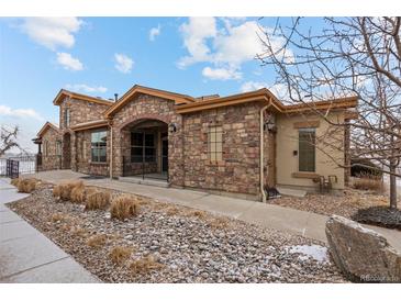 Charming exterior showcasing stone facade, arched entry, and professionally landscaped grounds at 2317 Primo Rd # A, Highlands Ranch, CO 80129
