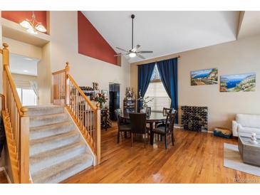 Bright dining room featuring hardwood floors, a decorative ceiling fan, and ample natural light from a large window at 13277 Elizabeth St, Thornton, CO 80241