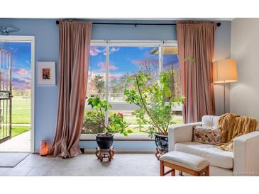 Bright living room features large windows with outdoor views, complemented by stylish furniture and decor at 6328 E Mississippi Ave, Denver, CO 80224