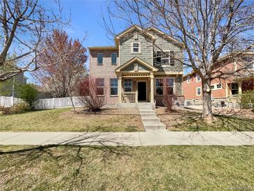 Charming two-story home with a combination brick and green siding exterior and a well-manicured lawn at 2245 Whistler Dr, Longmont, CO 80504