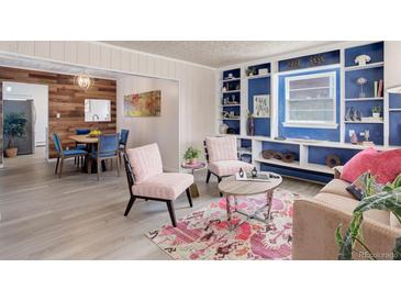 Cozy living room featuring built-in shelves and adjacent dining space with modern furnishings at 1270 Elmira St, Aurora, CO 80010