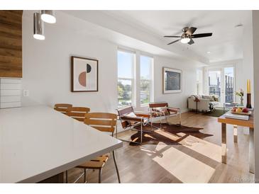 Bright living room featuring hardwood floors, modern furnishings, and abundant natural light from large windows at 1810 Irving St # 8, Denver, CO 80204