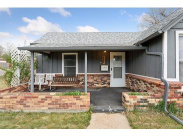 Charming home featuring a covered front porch with swing and brick accents at 4595 S Fox St, Englewood, CO 80110
