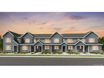 Charming townhome exterior showcasing a modern design with a landscaped front and neutral color palette at 17137 W 91St Ln, Arvada, CO 80007