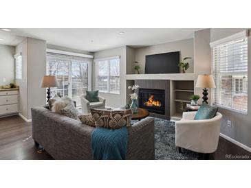 Comfortable living room featuring a fireplace, TV, and lots of comfortable seating at 14300 Waterside Ln # S2, Broomfield, CO 80023