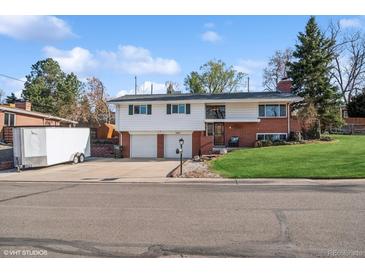 Charming split-level home featuring a two-car garage, brick accents, and a well-maintained front lawn at 11600 W 31St Pl, Lakewood, CO 80215