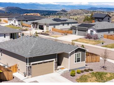 View of attractive single-Gathering home with well-maintained lawn and mountain views on a sunny day at 1694 Castle Vista Way, Castle Rock, CO 80104