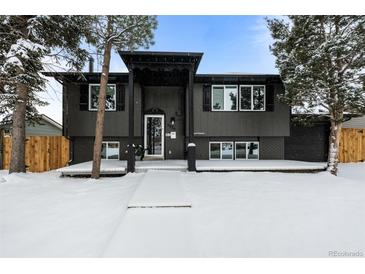 Updated bi-level home with a modern exterior, new deck, and snowy front yard at 3530 W Edgemore Pl, Englewood, CO 80110