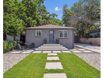 Charming home with gray exterior, stone walkway, and lush green lawn at 3050 S Delaware St, Englewood, CO 80110