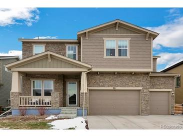 Charming two-story home featuring stone accents, neutral siding, and a two-car garage with a well-manicured front yard at 887 Sundance Ln, Erie, CO 80516