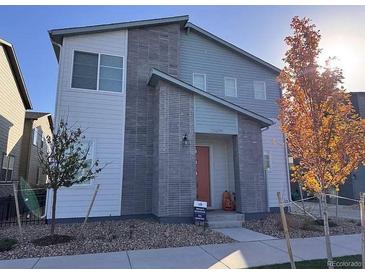 Two-story modern home with gray and white exterior, landscaping, and a paved walkway at 23670 E 41St Ave, Aurora, CO 80019