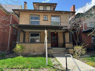 Charming two-story brick home with a covered porch and well-manicured front yard at 1451 N Gilpin St, Denver, CO 80218