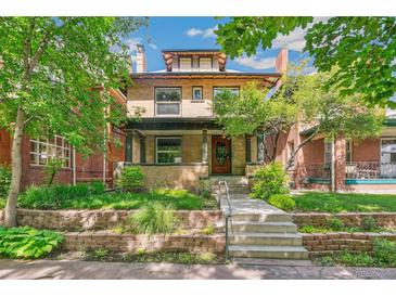 Charming two-story brick home featuring a landscaped front yard, covered porch, and a classic architectural design at 1451 N Gilpin St, Denver, CO 80218
