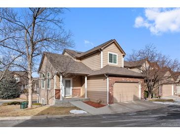 Tan two-story home with attached garage and landscaping at 6817 S Webster St # C, Littleton, CO 80128