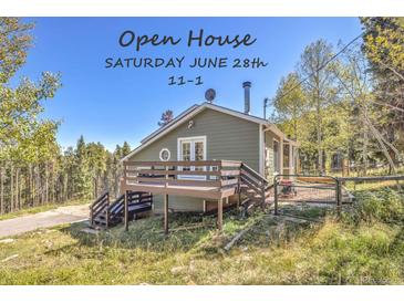 Cozy two-story home featuring a charming deck and a lush, natural setting in a mountain area at 32252 Steven Way, Conifer, CO 80433