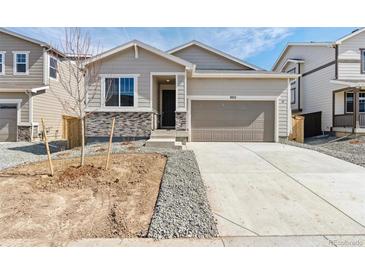 Charming single-Gathering home with a two-car garage and modern stone accents at 9712 Cathay St, Commerce City, CO 80022