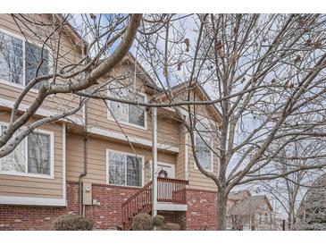 Charming townhome featuring wood siding, brick accents, and a cozy front porch at 6847 S Webster St # A, Littleton, CO 80128