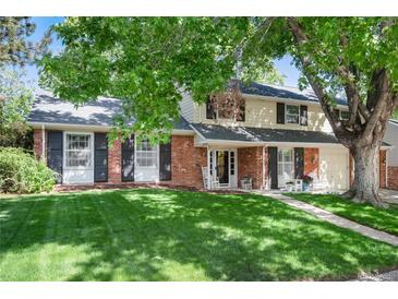 Charming two-story home with a brick facade, a well-manicured lawn, and mature trees in a suburban setting at 6624 S Sycamore St, Littleton, CO 80120