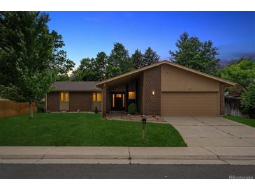 Charming single-Gathering home featuring a brick facade, manicured lawn, and attached two-car garage at 1843 S Pierson Ct, Lakewood, CO 80232