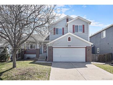 Charming two-story home with red window shutters, a well-kept lawn, and a two car garage at 1838 Wilson Cir, Erie, CO 80516