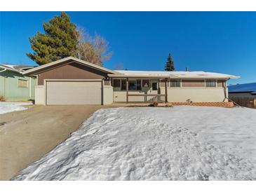 Ranch-style home with attached garage and snowy front yard at 14059 W 5Th Ave, Golden, CO 80401