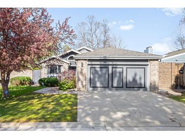 Charming single-story home with a well-manicured lawn, lush landscaping, and attached two-car garage at 8080 E Dartmouth Ave # 26, Denver, CO 80231