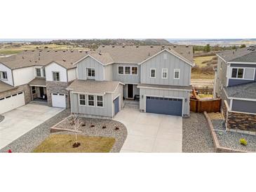 Beautiful two-story home with a gray exterior, well-maintained landscaping, and a two-car garage at 174 Rockingham Cir, Castle Pines, CO 80108