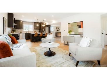 Open-concept living room with modern decor, including a stylish kitchen island and comfortable seating at 6325 W Portland Pl, Littleton, CO 80128