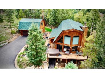A charming wood cabin home nestled amongst a mature forest with an outdoor hot tub at 12191 Tecumseh Trl, Conifer, CO 80433
