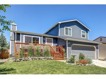 Charming home with a beautiful front yard, a wooden deck, and fresh exterior paint at 8463 Wheatgrass Cir, Parker, CO 80134