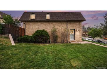 Charming brick two-story home with a well-maintained lawn and lush green bushes and trees at 5573 S Lowell Blvd, Littleton, CO 80123
