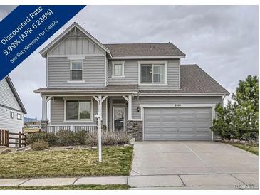 Charming two-story home with a covered front porch and an attached two-car garage at 8695 Torrey St, Arvada, CO 80007