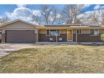 Charming ranch home featuring brick accents, solar panels, and a well-maintained front yard at 1255 S Hoyt St, Lakewood, CO 80232